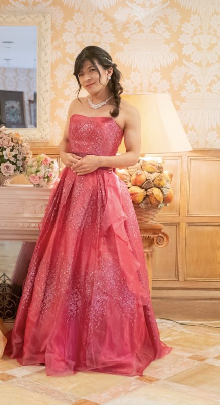 青木さん写真　黒髪のセミロング、上品な濃いピンクのドレス姿